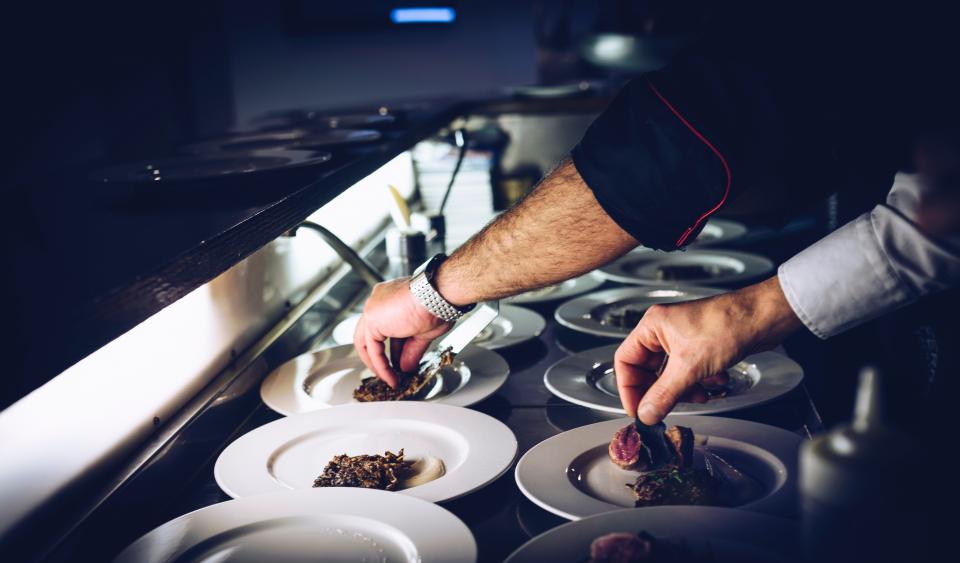 Chef finishing a plate at the pass during service