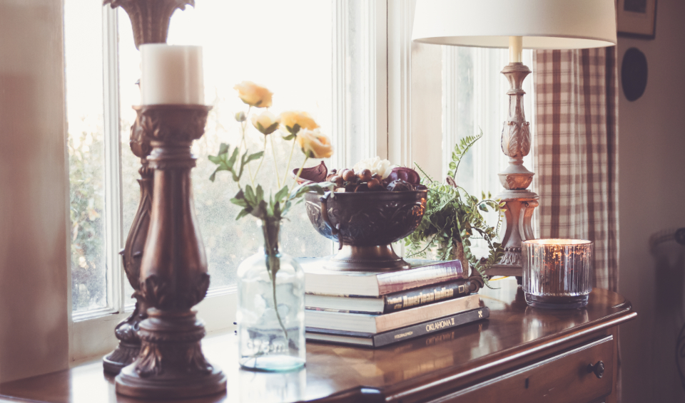 Floral arrangement styled on a console by a window